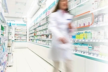 pharmacist contemplating prescription drug costs